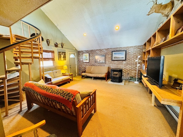 living room featuring brick wall, lofted ceiling, a textured ceiling, and a wood stove