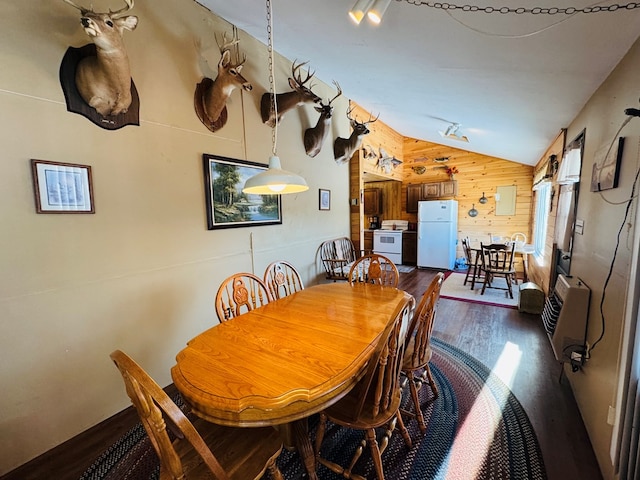 dining room with heating unit, vaulted ceiling, dark hardwood / wood-style floors, and wood walls