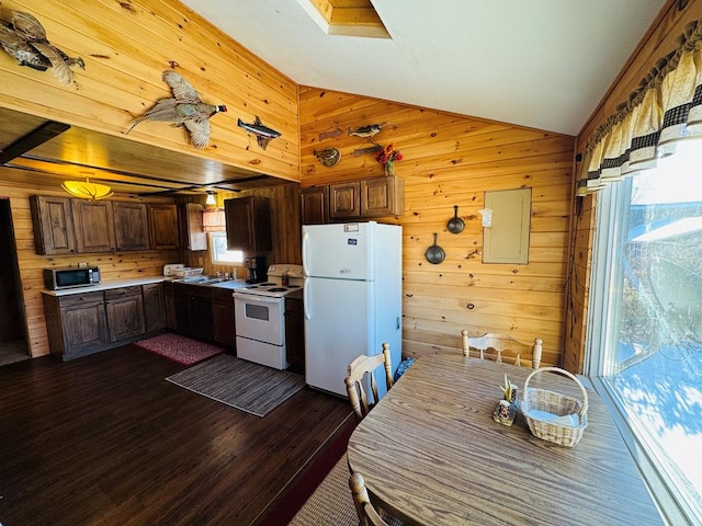 kitchen with vaulted ceiling, dark hardwood / wood-style floors, white appliances, and wood walls