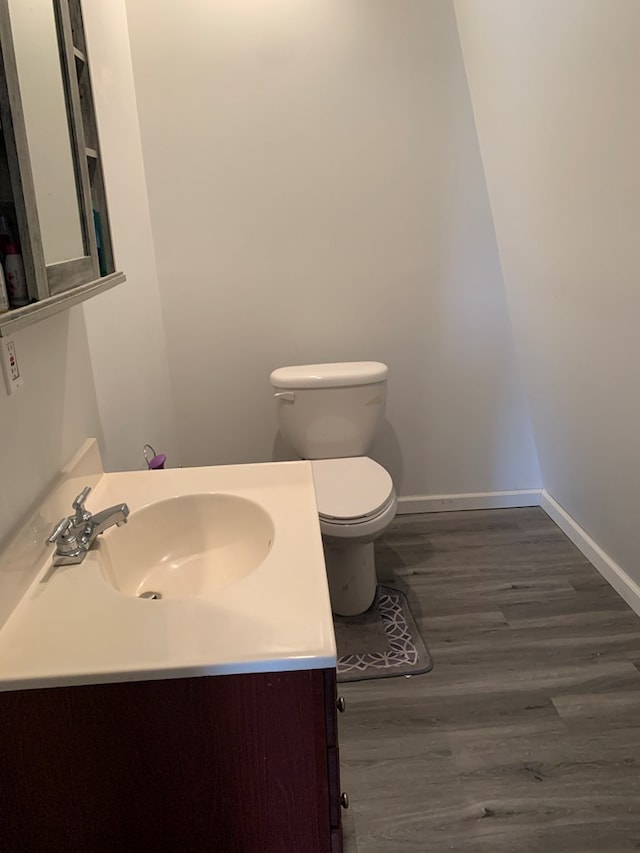 bathroom with vanity, hardwood / wood-style flooring, and toilet