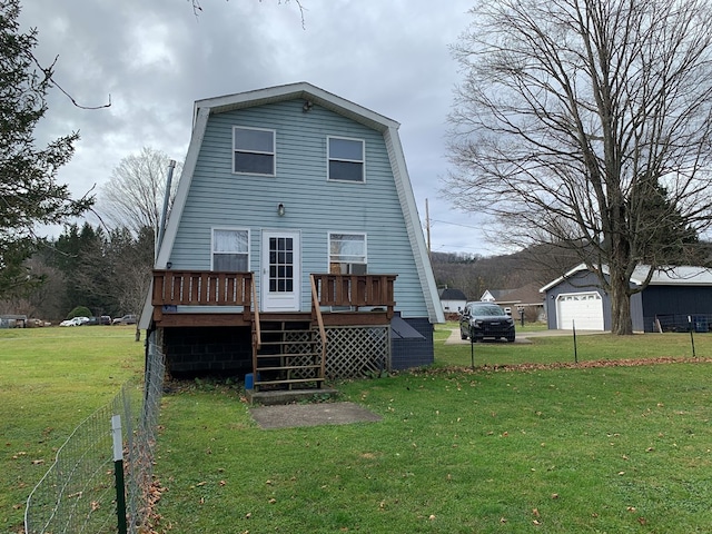 rear view of property with a garage, a wooden deck, and a lawn