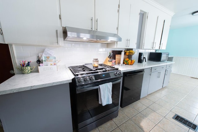 kitchen with decorative backsplash, white cabinets, black appliances, and light tile patterned floors