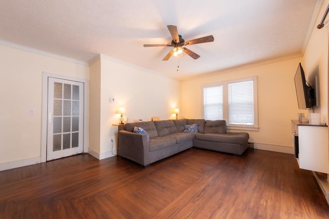 living room with crown molding, ceiling fan, and dark wood-type flooring