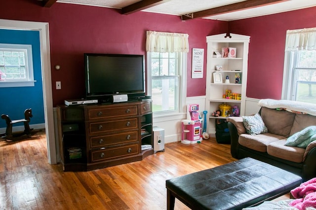 living room featuring beam ceiling and light wood-type flooring