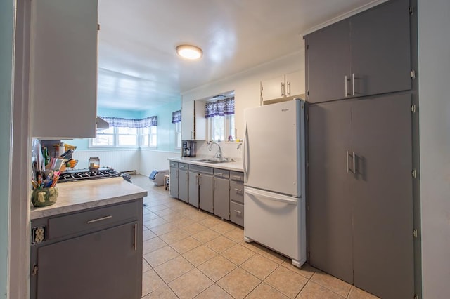 kitchen with sink, gray cabinets, light tile patterned floors, tasteful backsplash, and white fridge