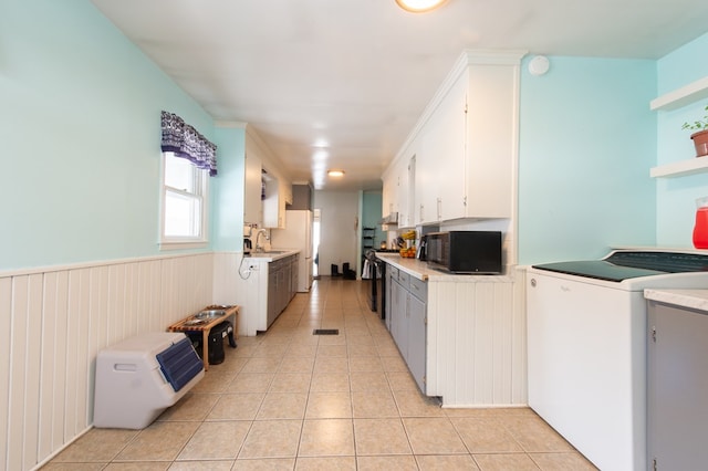 kitchen featuring white cabinetry, sink, white refrigerator, washer / dryer, and light tile patterned floors