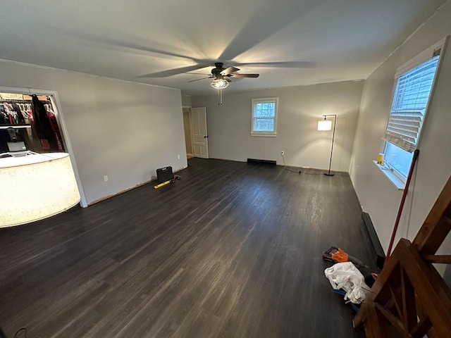 unfurnished living room featuring ceiling fan and dark hardwood / wood-style flooring