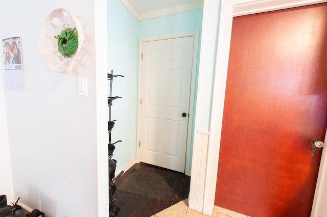 corridor with tile patterned floors and crown molding