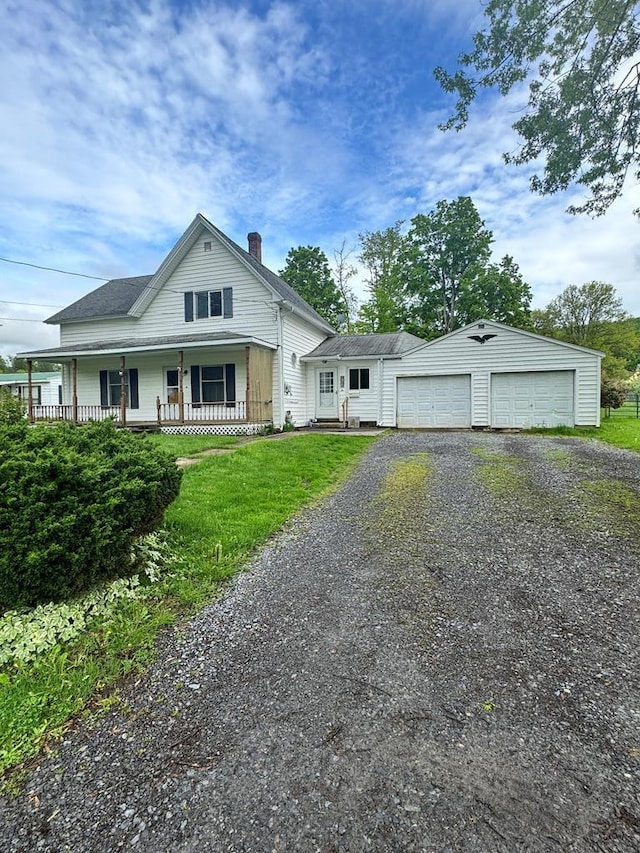 view of front of house featuring an outbuilding, covered porch, and a garage