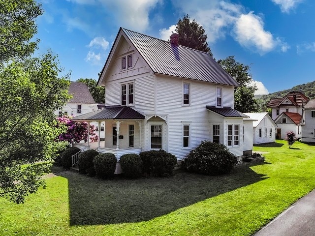 306 Broad St, Port Allegany, PA 16743 - view of front of house featuring a front yard, a porch, a metal roof, a chimney, and a standing seam roof