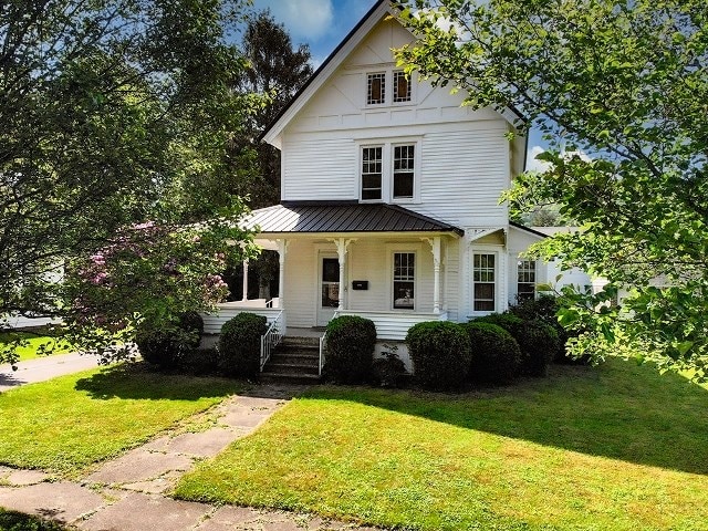 306 Broad St, Port Allegany, PA 16743 - view of front facade with a porch, a front yard, a standing seam roof, and a metal roof