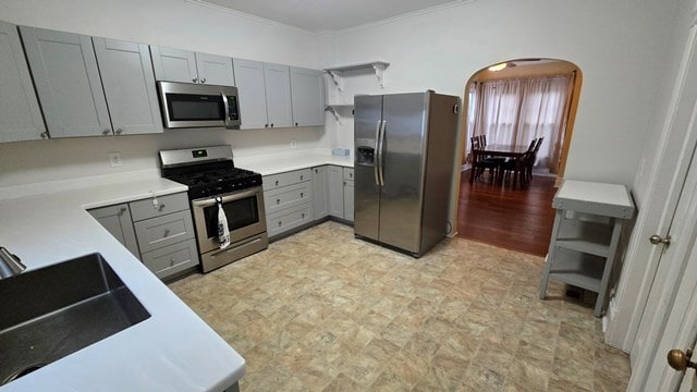 306 Broad St, Port Allegany, PA 16743 - kitchen featuring stainless steel appliances, gray cabinets, arched walkways, ornamental molding, and light countertops