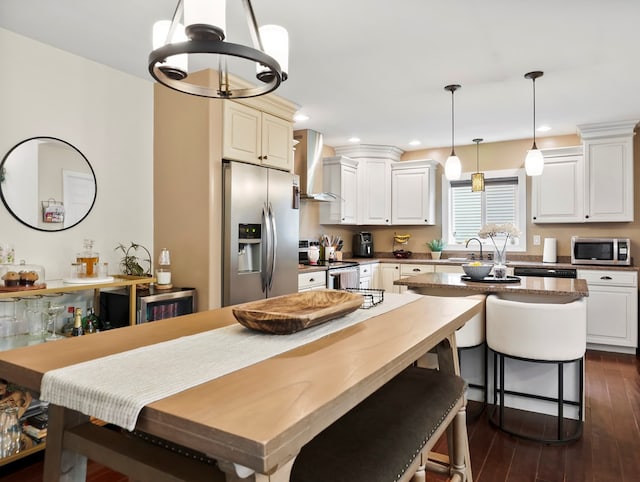 109 Alden St, Sayre, PA 18840 - kitchen with stainless steel appliances, wall chimney range hood, dark wood-style flooring, a breakfast bar area, and a kitchen island
