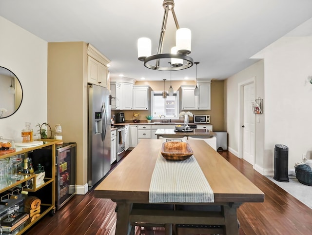 109 Alden St, Sayre, PA 18840 - dining room with dark wood-style floors, wine cooler, a chandelier, and baseboards
