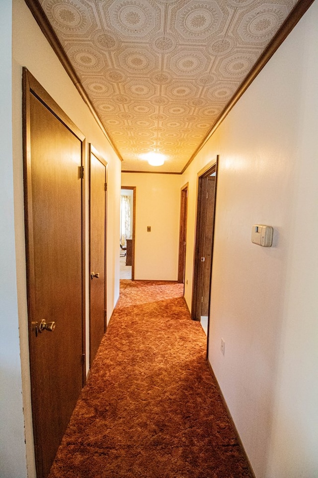 hall with carpet flooring and ornamental molding