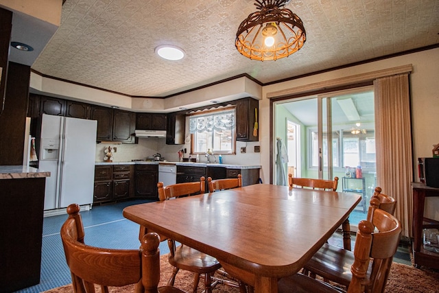 dining space featuring a wealth of natural light, crown molding, and sink