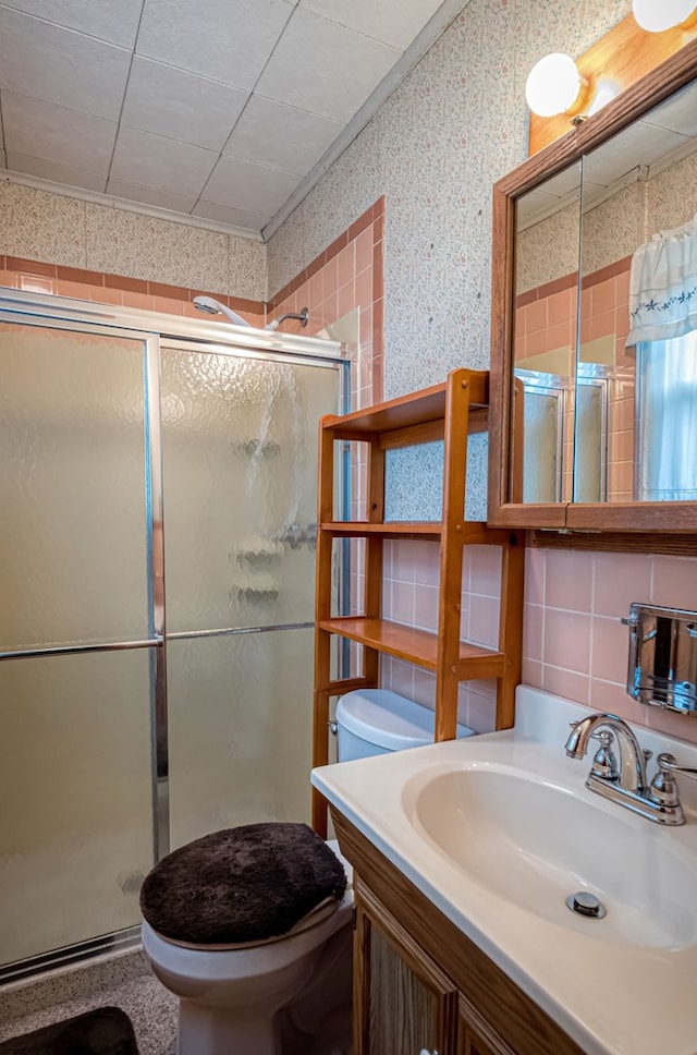 bathroom featuring vanity, a shower with shower door, and toilet