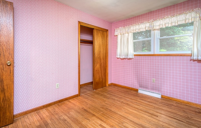 unfurnished bedroom with light wood-type flooring and a closet