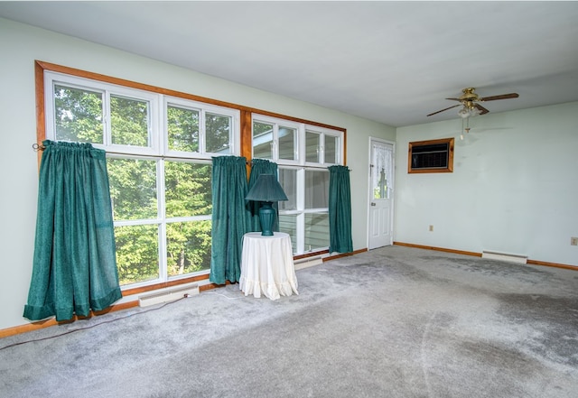 carpeted spare room featuring ceiling fan, a wall unit AC, and plenty of natural light