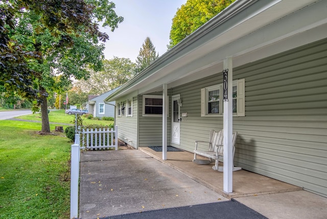 exterior space featuring a lawn and covered porch