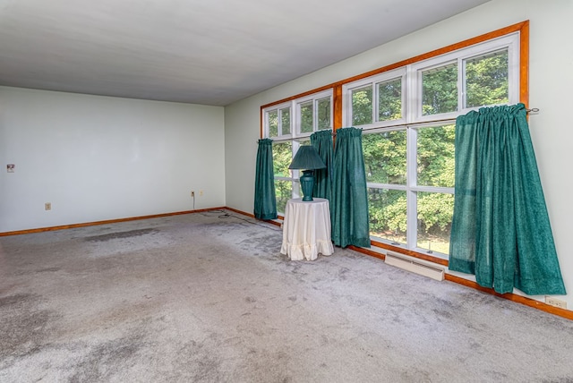 unfurnished room featuring a healthy amount of sunlight, carpet floors, and a baseboard heating unit