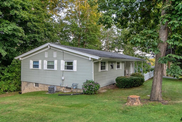 exterior space with cooling unit and a yard