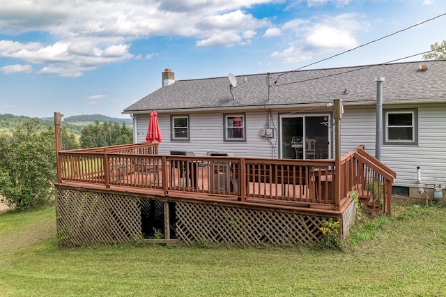 rear view of property featuring a wooden deck and a yard