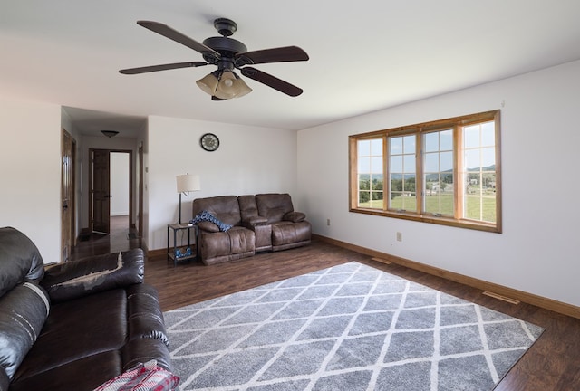 living room featuring ceiling fan and dark hardwood / wood-style flooring