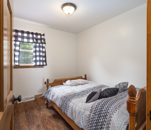 bedroom with dark hardwood / wood-style floors