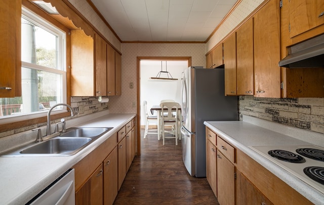 kitchen featuring appliances with stainless steel finishes, crown molding, sink, pendant lighting, and dark hardwood / wood-style floors