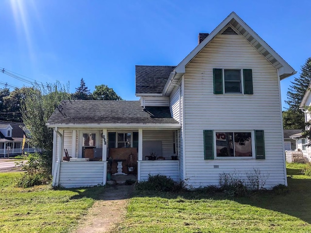 front facade featuring covered porch and a front yard