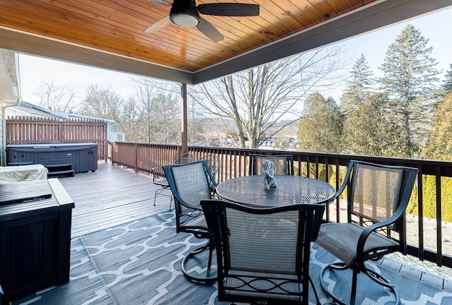 wooden deck with a hot tub and ceiling fan