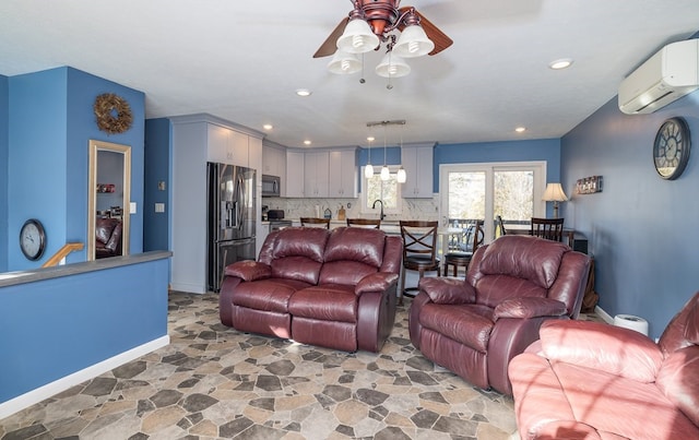 living room featuring sink, ceiling fan, and an AC wall unit