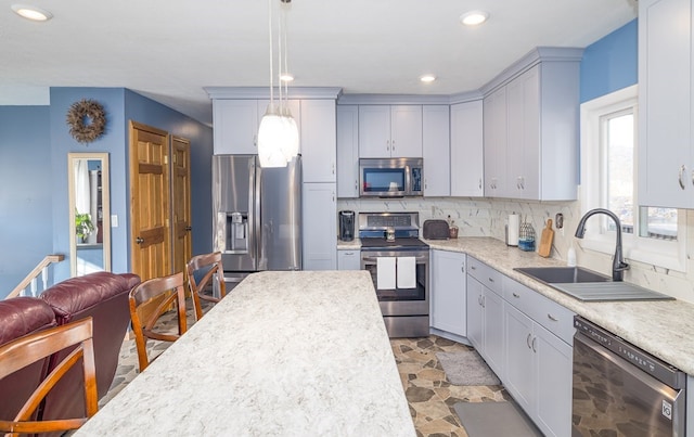 kitchen featuring decorative light fixtures, sink, stainless steel appliances, and tasteful backsplash