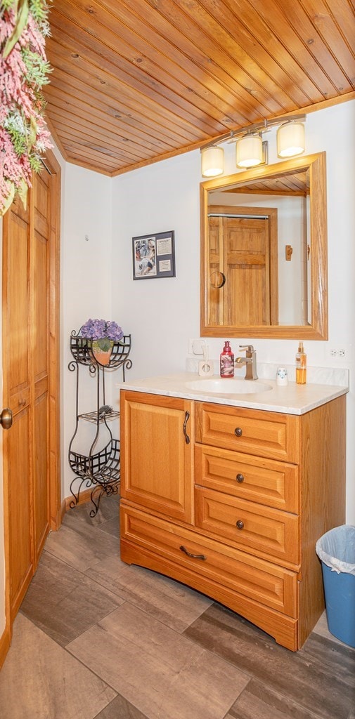 bathroom featuring ornamental molding, wood ceiling, and vanity