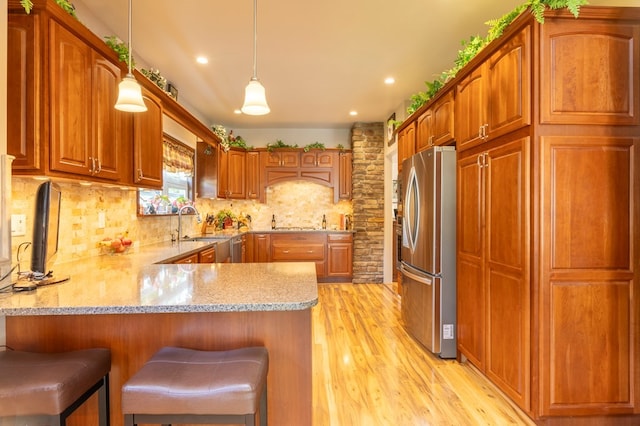 5 Eberenz St, Wellsboro, PA 16901 - kitchen with tasteful backsplash, light wood-type flooring, freestanding refrigerator, a peninsula, and brown cabinets