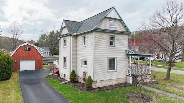 5 Eberenz St, Wellsboro, PA 16901 - view of side of home with an outbuilding, aphalt driveway, a shingled roof, a garage, and a yard