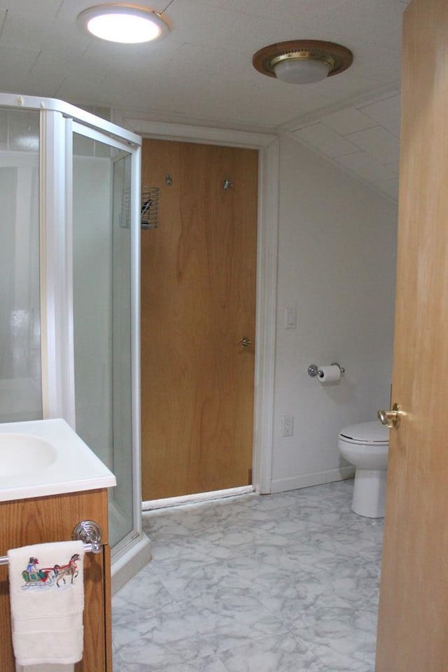 full bath with a stall shower, marble finish floor, vanity, and toilet