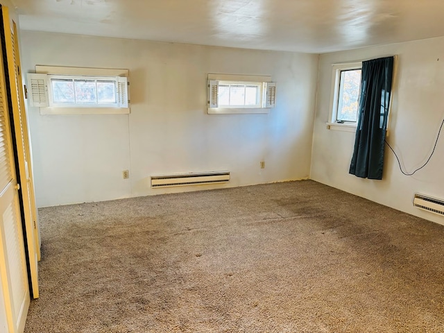 carpeted spare room featuring a baseboard heating unit