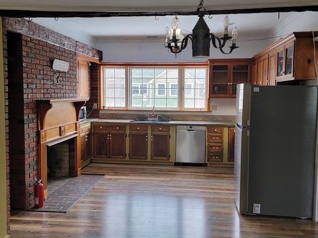 kitchen with sink, appliances with stainless steel finishes, hardwood / wood-style floors, and a chandelier