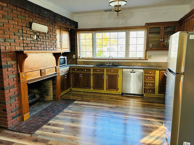 kitchen featuring appliances with stainless steel finishes, sink, crown molding, and dark hardwood / wood-style floors