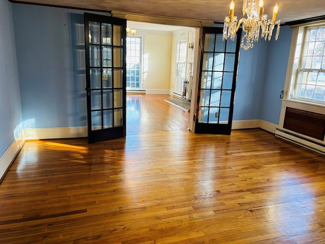 interior space featuring hardwood / wood-style floors, an inviting chandelier, crown molding, a baseboard radiator, and french doors