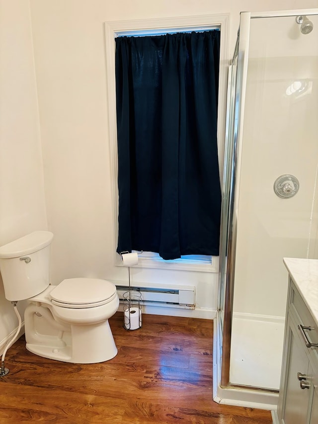 bathroom featuring vanity, a baseboard heating unit, toilet, walk in shower, and wood-type flooring