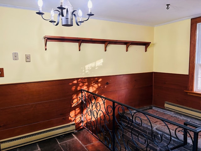 staircase featuring a baseboard heating unit, crown molding, wooden walls, and an inviting chandelier