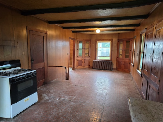 118 Wilbur St, Waverly, NY 14892 - kitchen featuring range with gas stovetop, radiator, wood walls, beam ceiling, and brick patterned flooring