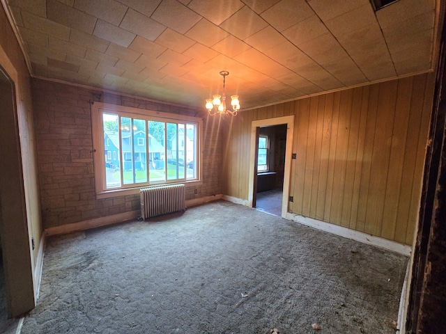 118 Wilbur St, Waverly, NY 14892 - empty room featuring radiator heating unit, a chandelier, carpet flooring, wooden walls, and baseboards