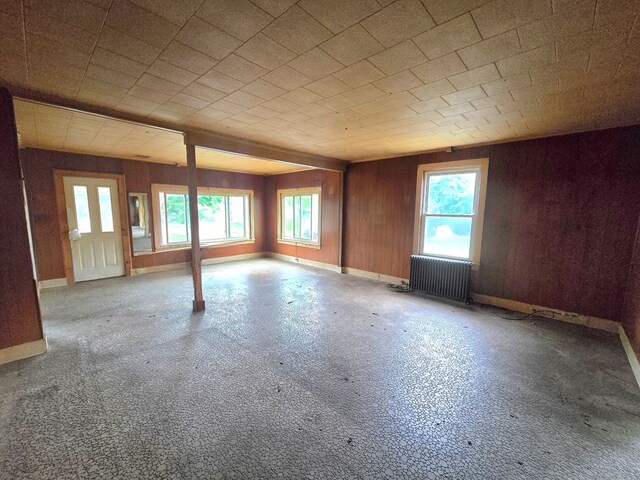 118 Wilbur St, Waverly, NY 14892 - unfurnished room with radiator, plenty of natural light, wood walls, and baseboards