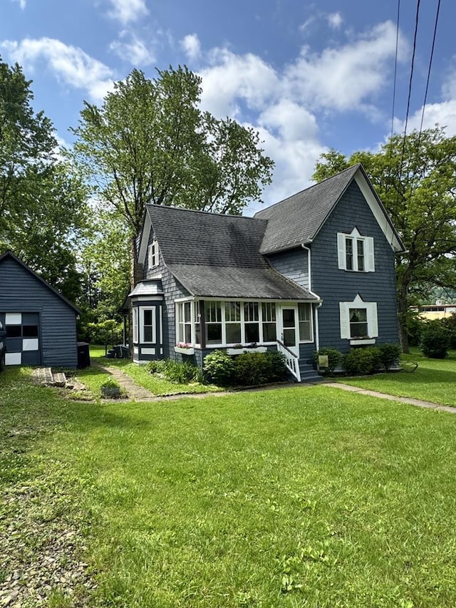 66 Benton St, Port Allegany, PA 16743 - view of front of home with a detached garage, a front lawn, a shingled roof, and an outbuilding