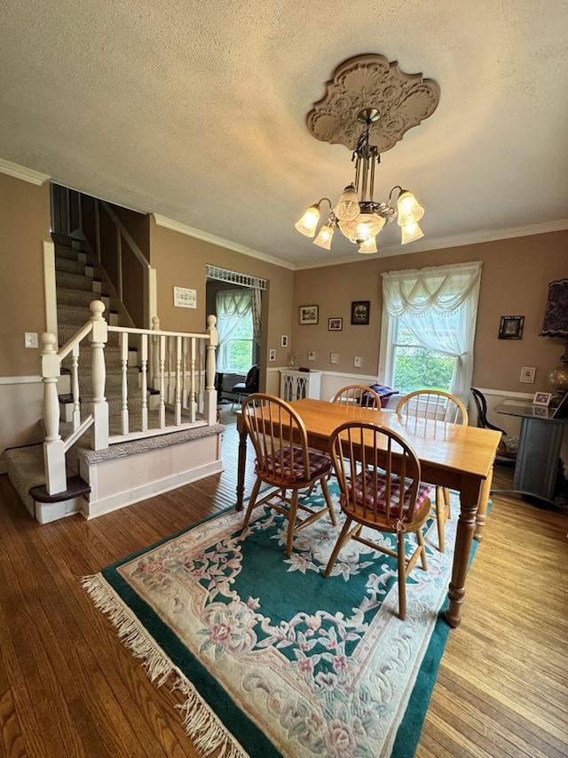 66 Benton St, Port Allegany, PA 16743 - dining space with stairs, crown molding, plenty of natural light, wood finished floors, and a textured ceiling