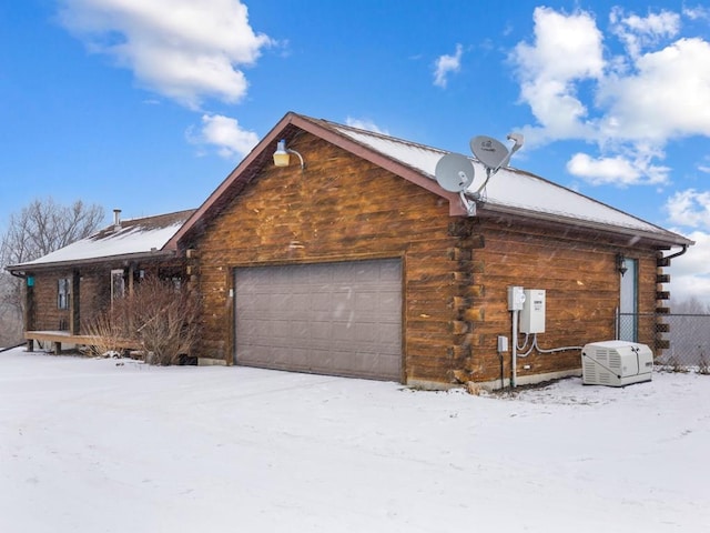 snow covered property with a garage